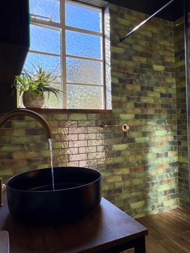 a bathroom with a large bath tub with a window at Eccentric Heritage Paradise Simon's Town in Simonʼs Town