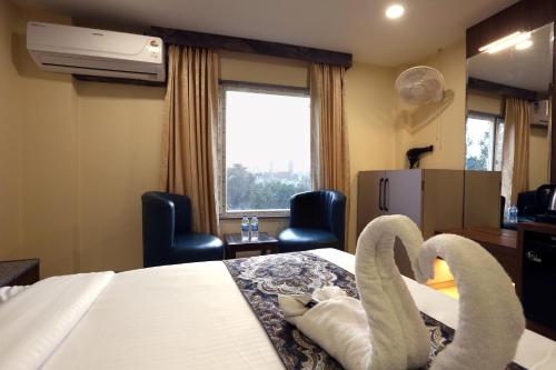 a hotel room with swan towels on a bed at Hotel GC Grand Inn By J R GROUP OF HOTELS in Amritsar