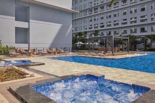 a swimming pool in front of a building at Grand Westside Manila Bay in Manila