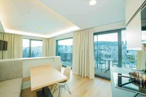 a living room and dining room with a view of the city at Summit of Saxony Resort Oberwiesenthal in Kurort Oberwiesenthal