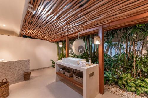 a bathroom with a sink and some plants at Villa Kimaya Bali in Badung