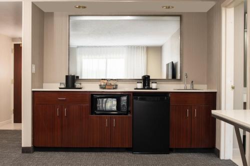 a kitchen with a sink and a mirror at Courtyard Seattle Sea-Tac Area in Tukwila