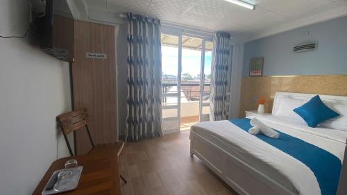 a bedroom with a bed and a large window at HUY HOANG II Hotel - Da Lat in Da Lat