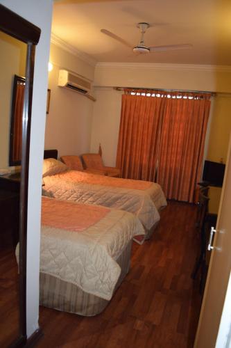 a hotel room with two beds and a window at Carlton Tower Hotel Lahore in Lahore