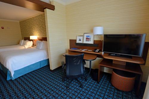 a hotel room with a desk with a computer and a bed at Fairfield Inn & Suites by Marriott Bowling Green in Bowling Green
