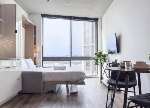 a bedroom with a bed and a table and a kitchen at Monthier The Wharf BLW9S5U7-2 in Washington, D.C.