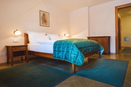 a bedroom with a bed with a blue blanket on it at Apartments Esplanade in Špindlerův Mlýn