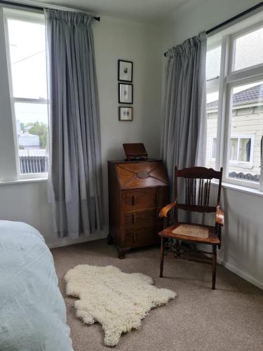 a bedroom with a chair and a desk and window at Seamstress Cottage in Marton