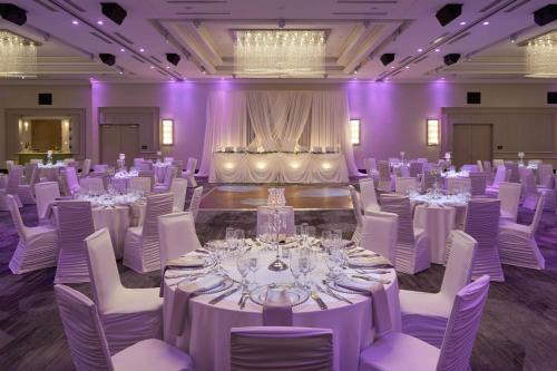 a ballroom with white tables and chairs and purple lighting at Courtyard by Marriott Oshawa in Oshawa