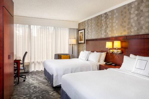 a hotel room with two beds and a desk at Courtyard Fairfield Napa Valley Area in Fairfield