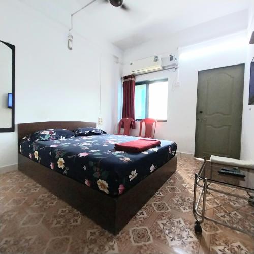 a bedroom with a bed and a flat screen tv at Sunita niwas in Malvan