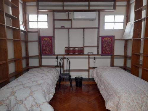a room with two beds and a chair in it at Apartamento del bufete in Buenos Aires