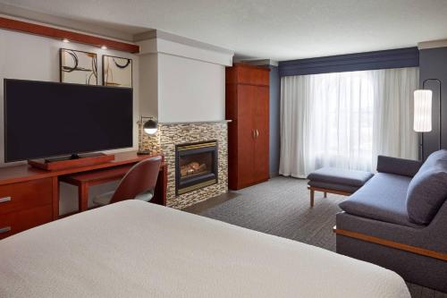 a hotel room with a bed and a fireplace at Courtyard by Marriott Waterloo St. Jacobs in Waterloo