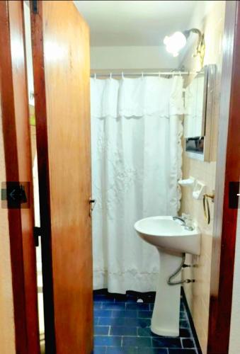 a bathroom with a sink and a white shower curtain at San Bernardo in San Bernardo