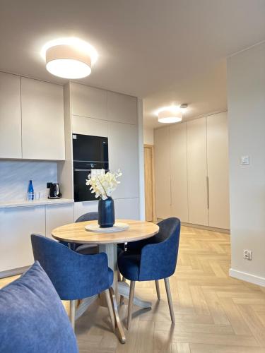 a kitchen with a table and chairs with a vase of flowers at Apartament Premium Zamkowa B12 in Tczew