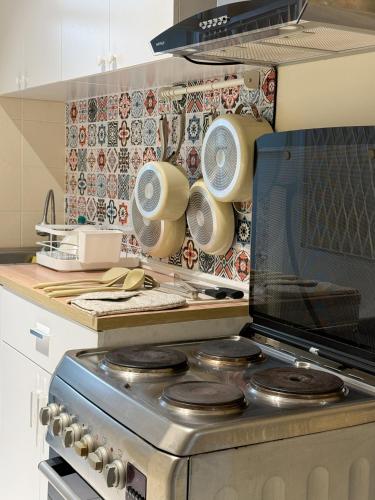 a kitchen with a stove with pots and pans at 3 Bedroom NORDIC HOME Full Kitchen 8 MINS to MRT & JODD Fair & near RCA in Bangkok