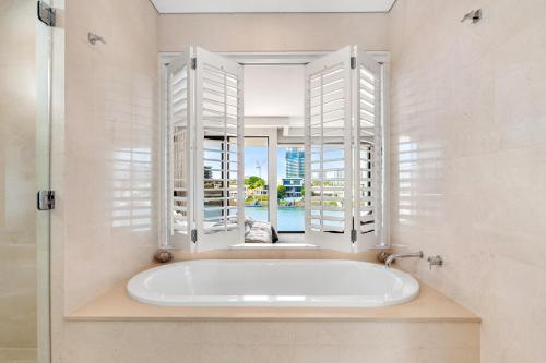 a bath tub in a bathroom with a window at 3 m Luxury Waterfront Villa in Paradise Pets Welcome in Gold Coast