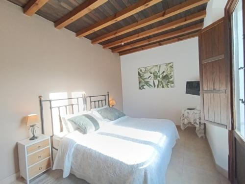 a white bedroom with a bed and a window at Hotel La Perla Blanca in Ronda
