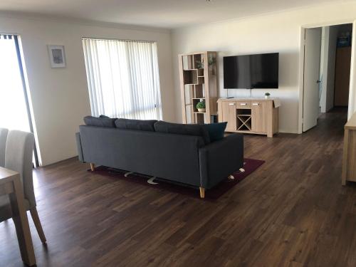 a living room with a couch and a flat screen tv at 4 Bedroom Wandina Home - 5 TVs & Close to Shopping Centre in Geraldton