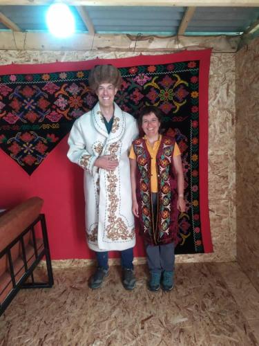 a man and a woman standing next to a wall at Ulan Camp in Kol-Suu