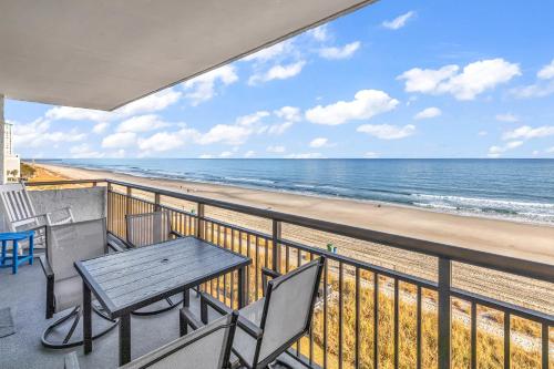 a balcony with a table and chairs and the beach at Bluewater Resort 502 in Myrtle Beach