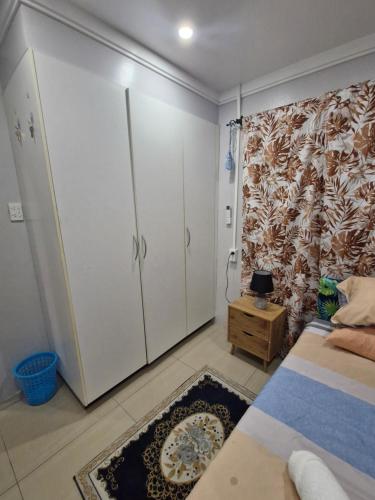 a bedroom with a bed and a cabinet and a rug at Tropical Almond Haven in Suva