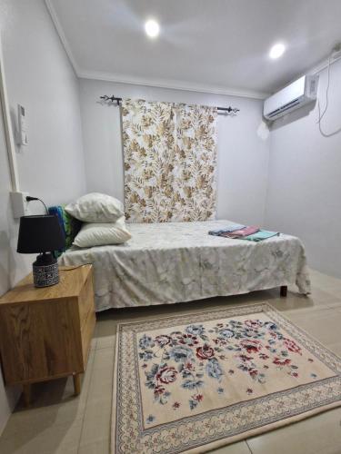 a small bedroom with a bed and a rug at Tropical Almond Haven in Suva