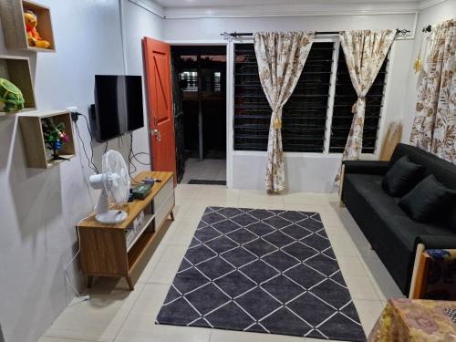 a living room with a black couch and a tv at Tropical Almond Haven in Suva