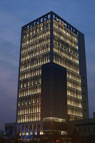 a tall building with lights in front of it at Courtyard by Marriott Shanghai Jiading in Jiading