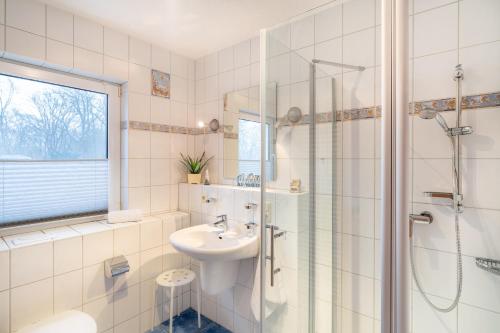 a white bathroom with a sink and a shower at Düneneck 09 in Zempin