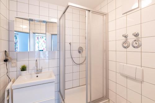 ツィノヴィッツにあるDünenresidenz 22のシャワーと洗面台を備えた白いバスルーム
