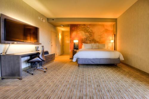 a large hotel room with a bed and a desk at Courtyard by Marriott Pigeon Forge in Pigeon Forge