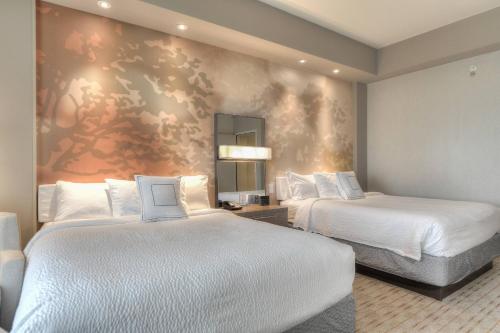 a hotel room with two beds and a painting on the wall at Courtyard by Marriott Pigeon Forge in Pigeon Forge