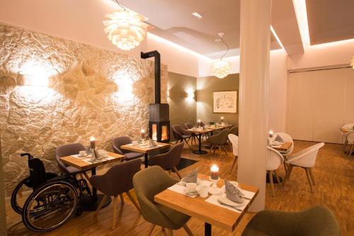 a restaurant with tables and chairs and a wall at Hotel Strand26 an der Ostsee in Ostseebad Nienhagen