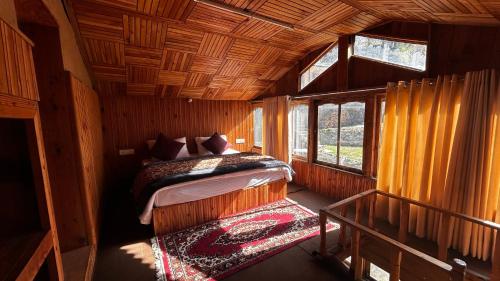 a bedroom with a bed in a wooden cabin at PineNest Cottages & Cafe in Jibhi