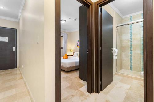 y baño con cama y ducha a ras de suelo. en PC312 - Pool View - 1BR Perfect for a couple - Close to Palm Beach, en Palm-Eagle Beach