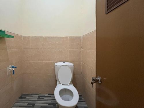 a bathroom with a white toilet in a stall at Wisma Salak Family Guest House Syariah RedPartner in Madiun