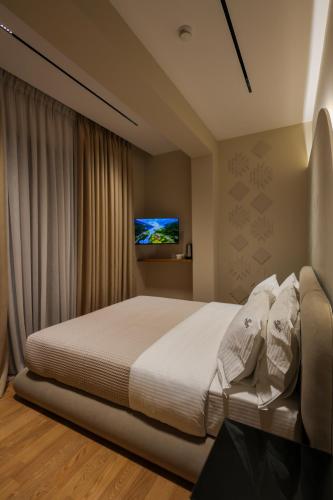 a bedroom with a bed and a tv on the wall at Beratinus1 in Berat