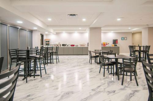 a dining room with tables and chairs and a counter at Wingate by Wyndham Tuscaloosa in Tuscaloosa