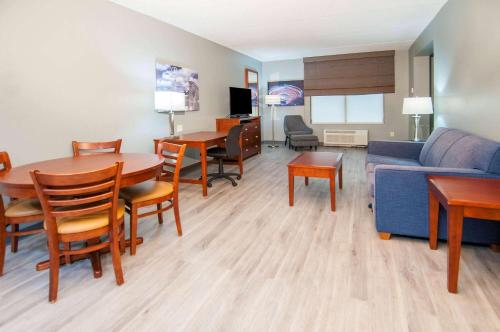 a living room with a couch and a table and chairs at Wingate by Wyndham Tuscaloosa in Tuscaloosa