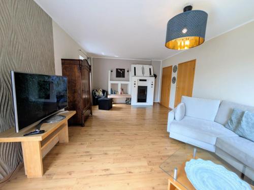 a living room with a couch and a flat screen tv at Ahrtal Vier Sterne Ferienwohnungen Alexandra Weiler Ferienwohnung Harmonie in Bad Neuenahr-Ahrweiler
