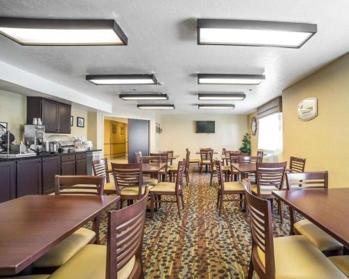a restaurant with tables and chairs and a kitchen at Sleep Inn West Valley City - Salt Lake City South in West Valley City