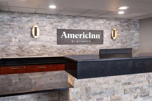 a sign for an american firm on a wall at AmericInn by Wyndham Beaver Dam in Beaver Dam