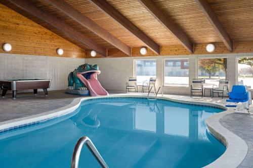 a swimming pool with a slide in a building at AmericInn by Wyndham Beaver Dam in Beaver Dam