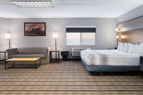 a hotel room with a bed and a couch at AmericInn by Wyndham Beaver Dam in Beaver Dam