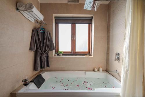a white tub in a bathroom with a window at SaffronStays Timber Crest in Dehradun