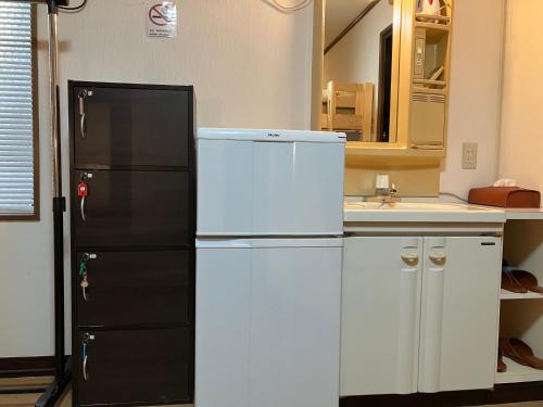 a kitchen with a black and white refrigerator at Cote House in Osaka