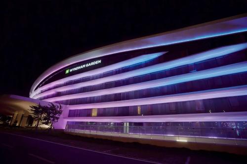 a building with a sign on it at night at Wyndham Garden Jinjiang in Jinjiang