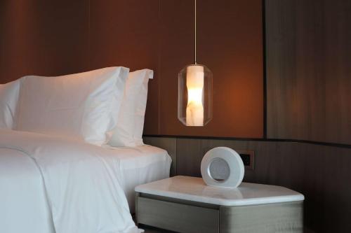 a hotel room with a bed and a night stand at Wyndham Garden Jinjiang in Jinjiang