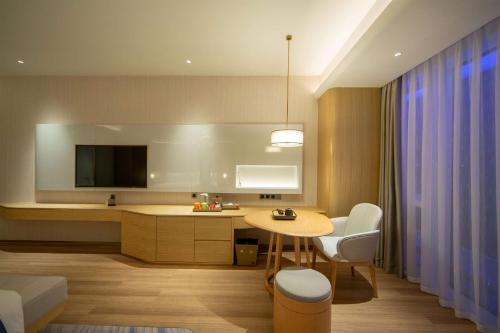 a kitchen with a table and chairs and a tv at Wyndham Garden Jinjiang in Jinjiang